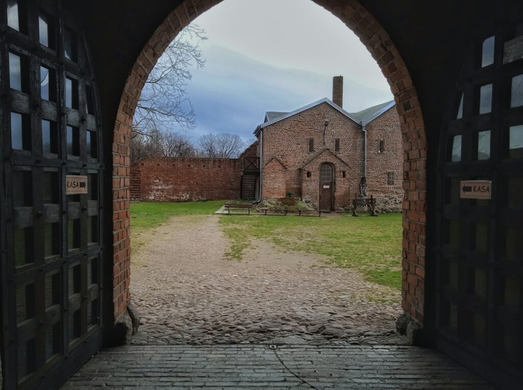 Łęczycanie – historia, tożsamość i dziedzictwo mieszkańców ziemi łęczyckiej a large brick building with an arched doorway